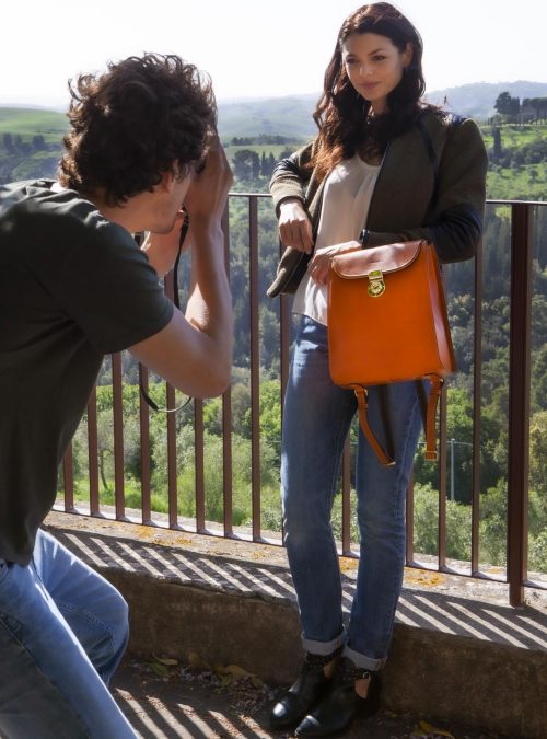 Ragazza con in mano una borsa Chiarugi Firenze, sullo sfondo paesaggio Toscano. Toscana.