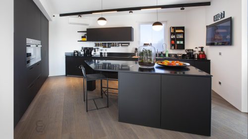 Particolare di cucina nera di alto design con isola centrale.